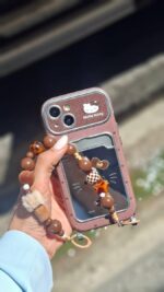 قاب جاکارتی‌دار طرح هلو کیتی آینه‌ای به همراه آویز گوشی آیفون 17